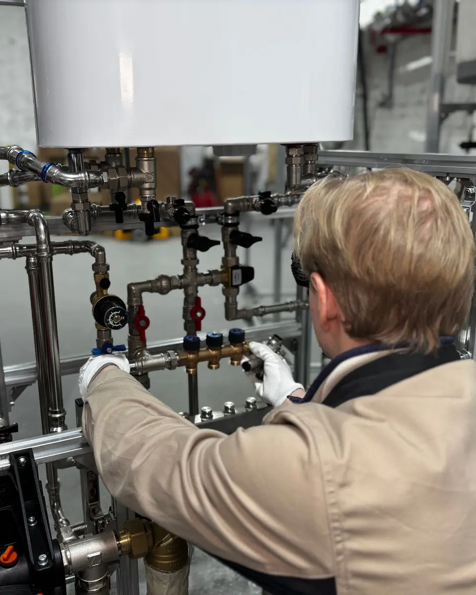 Engineer working on boiler pipework and controls